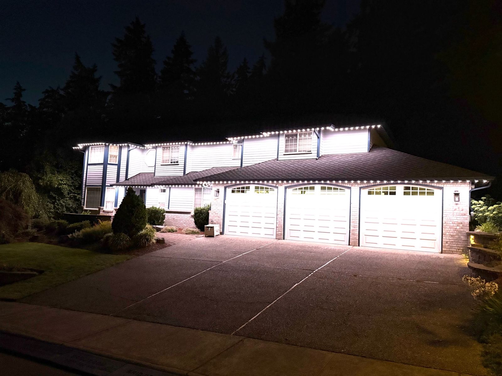 Washington home with bright white permanent roofline lighting at night